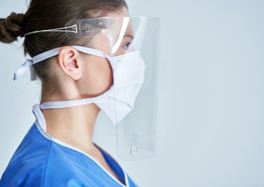 female healthcare worker wearing clear reusable face shield