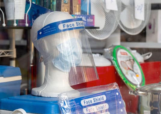 clear ppe face shield mounted on a mannequin head that's wearing a face mask